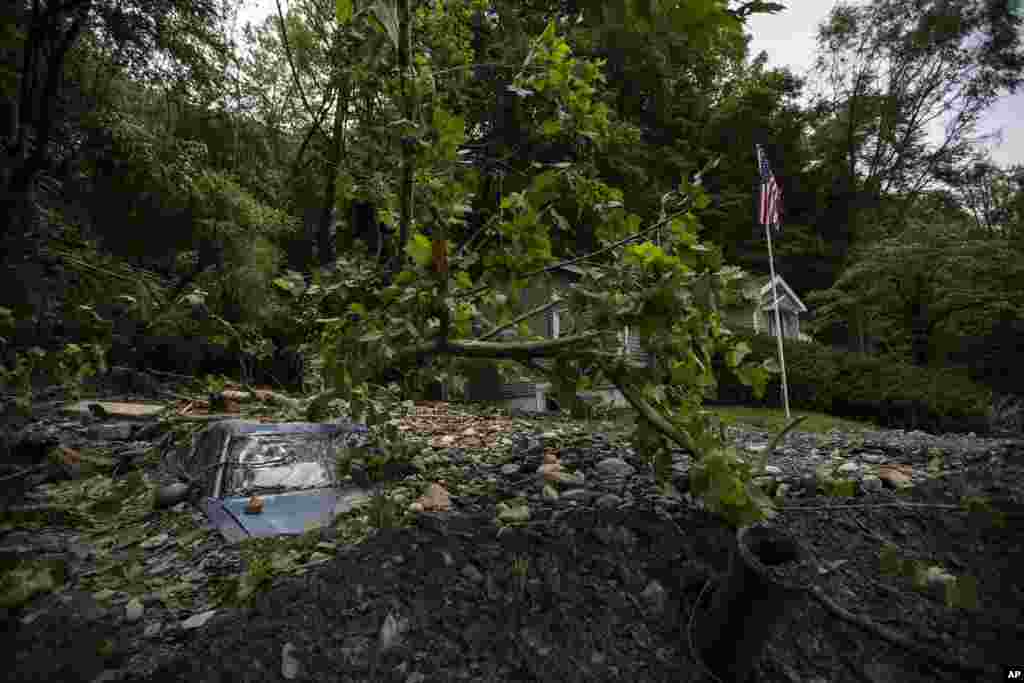 A car is buried in mud and rocks from recent flooding in Belvidere, New Jersey.