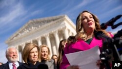 FILE - Lorie Smith, a Christian graphic artist and website designer in Colorado, right, accompanied by her lawyer, Kristen Waggoner of the Alliance Defending Freedom, second from left, speaks outside the Supreme Court in Washington, Dec. 5, 2022.