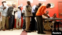 FILE - Zimbabweans receive forms as they queue to apply for residence and study permits outside the Home Affairs office in Cape Town, December 31, 2010. 