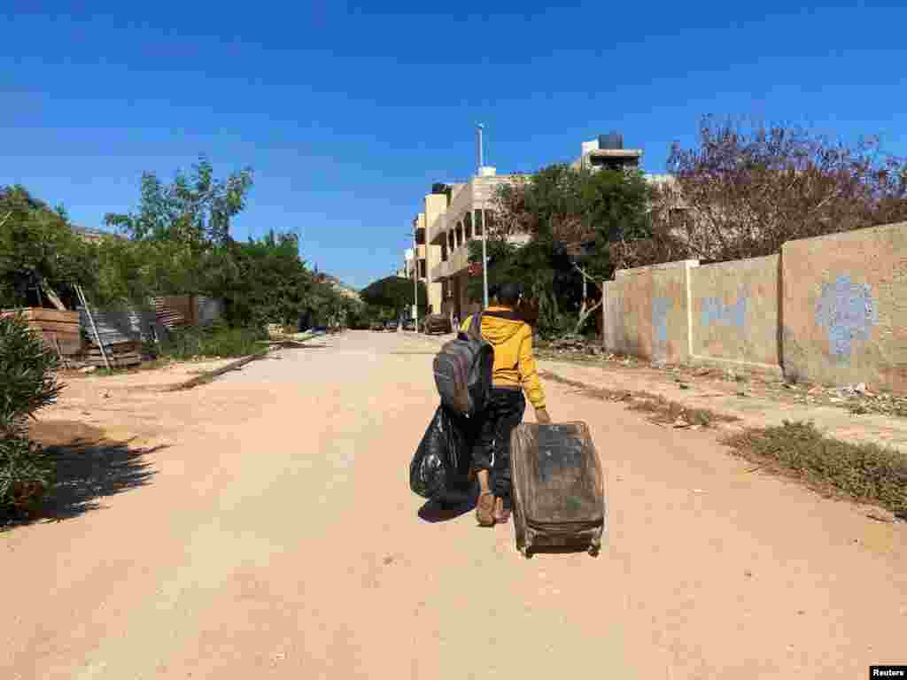 A man carries his belongings in the aftermath of the floods in Derna, Sept. 14, 2023.