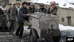 阿富汗工人在潘杰希爾省米克尼山谷的一個祖母綠礦推著一輛裝滿礦石的車