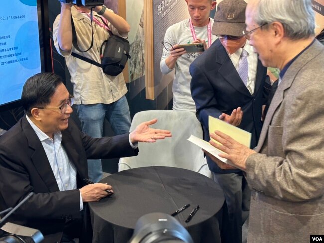 台灣國史館2月20日發表前總統陳水扁的訪談回憶錄新書。 陳水扁為扁迷在新書上簽名。 (美國之音特約記者楊安攝影)