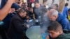 Palestinians collect food at a donation point provided by a charity group in the southern Gaza Strip city of Rafah, Dec. 6, 2023.