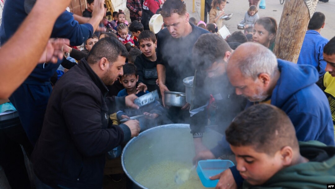Palestinos recolectan alimentos en un punto de donación proporcionado por un grupo de caridad en la ciudad de Rafah, en el sur de la Franja de Gaza, el 6 de diciembre de 2023.