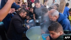 Palestinos recolectan alimentos en un punto de donación proporcionado por un grupo de caridad en la ciudad de Rafah, en el sur de la Franja de Gaza, el 6 de diciembre de 2023.
