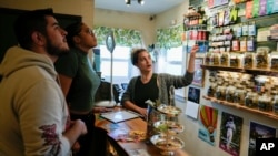 Twyla Bessey, right, helps customers buy cannabis at Home Grown Apothecary, April 19, 2024, in Portland, Oregon.
