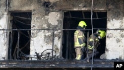 Firefighters remove a charred body inside a burned block building in Valencia, Spain, Feb. 23, 2024.