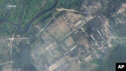 FILE - Satellite image by Planet Labs PBC taken June 15, 2023, shows a former military base near Osipovichi, Belarus with no signs of the structures that appeared two weeks later.