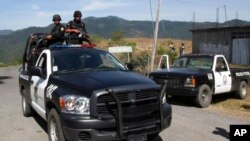 ARCHIVO - En esta fotografía del 28 de abril de 2010, la policía estatal custodia la entrada al pueblo de San Juan Copala, México, después de que hombres armados tendieran una emboscada a una caravana de activistas de derechos humanos.