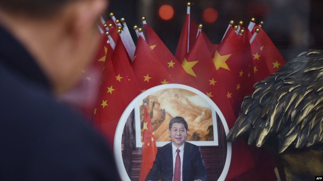 FILE - A man looks at a decorative plate featuring an image of Chinese President Xi Jinping at a souvenir store next to Tiananmen Square in Beijing on Feb. 27, 2018.