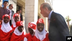 Turkey's President Recep Tayyip Erdogan speaks to Somali girls outside the new Turkish embassy in Mogadishu, Somalia, June 3, 2016. Turkey has assisted Somalia with development and a Turkish bank, Ziraat Katilim, opened in Mogadishu on Oct. 29, 2023.