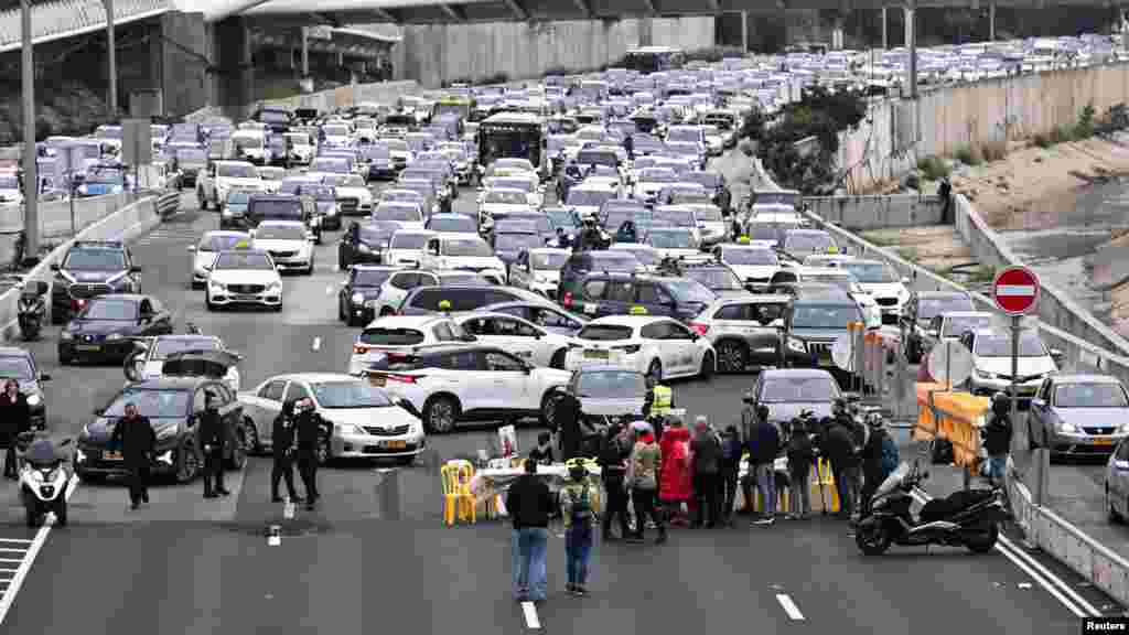 Friends, family members and supporters of hostages kidnapped in the Oct. 7 attack on Israel by Hamas block a road during a protest calling for their release, in Tel Aviv, Israel.