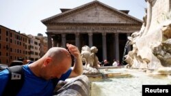A man cools off at a fountain near the Pantheon, during a heat wave across Italy, in Rome, July 19, 2023.