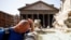 A man cools off at a fountain near the Pantheon, during a heat wave across Italy, in Rome, July 19, 2023.