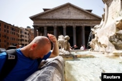 Seorang pria mendinginkan diri di air mancur dekat Pantheon, saat gelombang panas melanda Italia, di Roma, 19 Juli 2023. (Foto: Reuters)