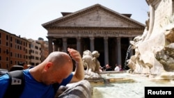 Seorang pria mendinginkan diri di air mancur dekat Pantheon, saat gelombang panas melanda Italia, di Roma, 19 Juli 2023. (Foto: Reuters)