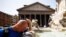 Seorang pria mendinginkan diri di air mancur dekat Pantheon, saat gelombang panas melanda Italia, di Roma, 19 Juli 2023. (Foto: Reuters)