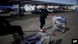 Uruguayan Diana Rocco heads to her car with a full shopping cart outside a super market in Gualeguaychu in the province of Entre Rios, Argentina, June 30, 2023. 