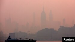 Gedung Empire State di New York City dipotret setelah matahari terbit saat kabut dan asap tebal akibat kebakaran hutan di Kanada menyelimuti langit Manhattan, seperti yang terlihat dari kota Jersey City, New Jersey, 8 Juni 2023 lalu.