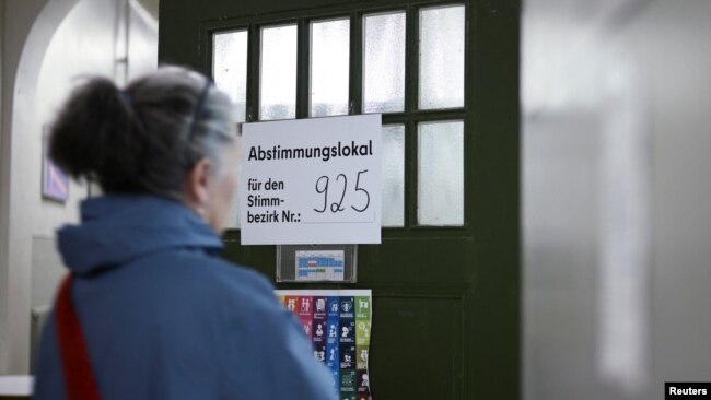 A woman enters a polling station during the 'Berlin 2030 Climate Neutral' referendum in Berlin, Germany, March 26, 2023.