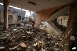 Seorang warga Palestina memeriksa kehancuran rumahnya setelah serangan Israel di Jalur Gaza di Khan Younis, 3 November 2023. (Foto: AP)