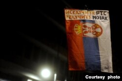 Građani nose transparent sa protestnom porukom protiv izveštavanja RTS-a prikačenom na zasetavu Srbije, tokom 20. protestu "Srbija protiv nasilja", u Beogradu, 16. septembra 2023. (Foto: FoNet)