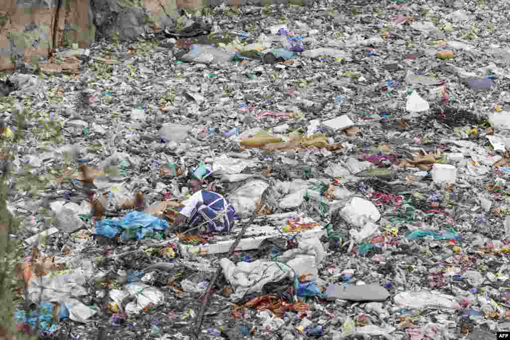 A volunteer searches through a trash dump for human remains at Mukuru slum in Nairobi, Kenya, July 14, 2024.&nbsp;Eight female bodies have been recovered so far from a dumpsite in a Nairobi slum. The mutilated and dismembered bodies, trussed up in plastic bags, were hauled out of a sea of floating rubbish in the abandoned quarry.