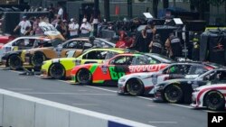 Pit crew members work on race cars during qualifying for the Grant Park 220 NASCAR Cup Series Race, July 1, 2023, in downtown Chicago.