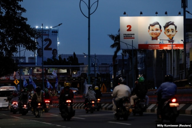 Masyarakat berjalan melewati baliho Menteri Pertahanan dan calon Presiden Prabowo Subianto dan pasangannya Gibran Rakabuming Raka di Jakarta, 12 Januari 2024. (Foto: REUTERS/Willy Kurniawan)