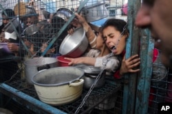 FILE — Palestinians seek food at Jabaliya refugee camp in the Gaza Strip, March 18, 2024.
