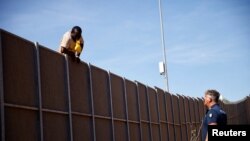 A policeman talks to a migrant trying to escape from the hotspot, on the Sicilian island of Lampedusa, Italy.