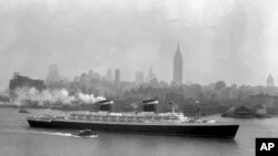 FILE - The SS United States glides down the Hudson River as it begins its first voyage to Europe from New York in view of the Manhattan skyline, in this view from Hoboken, New Jersey, July 3, 1952.