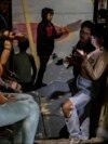 FILE - Migrants take a break from doing chores at the Agape migrant shelter in Tijuana, Mexico, Sept. 26, 2023.