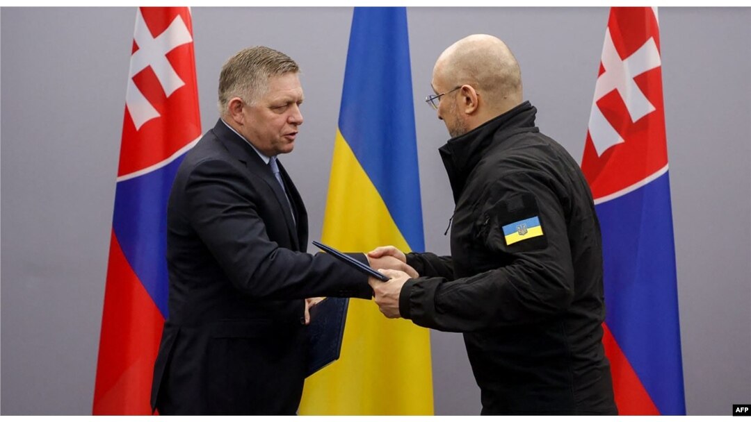 Denys Shmyhal (kanan) dan mitranya dari Slovakia Robert Fico bertukar folder dengan dokumen yang ditandatangani selama pertemuan mereka di Uzhhorod, 24 Januari 2024, di tengah invasi Rusia ke Ukraina. (HANDOUT / FACEBOOK / AFP)