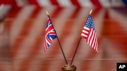 Bendera Inggris Raya dan Amerika Serikat terlihat di atas meja selama pertemuan dengan Menteri Pertahanan Lloyd Austin dan Menteri Pertahanan Inggris Ben Wallace di Pentagon, Senin, 17 April 2023, di Washington. (Foto: AP)