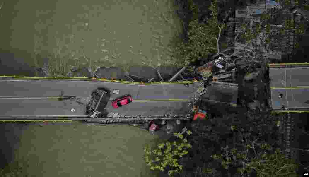 Cars are seen on and under the El Alambrado bridge after it collapsed the previous day in Caicedonia, Colombia.