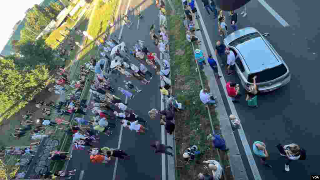 Građani tokom blokade auto-puta, nakon protesne vožnje, kod Sava centra na Novom Beogradu, 30. juna 2023. (Foto: Glas Amerike/Rade Ranković)