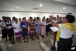 Timorese women sing during mass at a church In Dili, East Timor, Aug. 11, 2024. Most in the deeply Catholic country have downplayed or dismissed child sex abuse claims against two beloved clergymen.