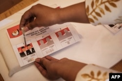Seorang pendukung calon presiden Anies Baswedan dan calon wakil presiden Muhaimin Iskandar melakukan simulasi pemungutan suara dalam kampanye yang diselenggarakan oleh relawan pemuda di Jakarta pada 8 Februari 2024. (Foto: AFP)