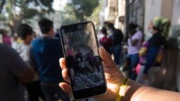 Seorang migran pengguna TikTok migran melihat saran dari migran pengguna lainnya, sebelum bergerak menuju perbatasan AS di luar Komisi Bantuan Pengungsi Meksiko (COMAR) di Mexico City, 14 Maret 2023. (CLAUDIO CRUZ/AFP)
