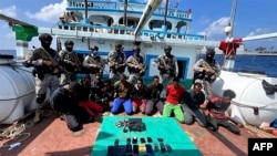 Indian commandos stand guard with a group of detained pirates after the Indian navy freed an Iranian fishing vessel hijacked by Somali pirates, off the Somali coast, west of Kochi, India, Jan. 30, 2024. (Indian navy photo)