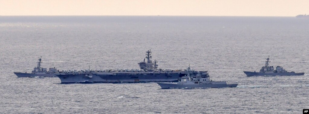 美国海军尼米兹号航母（USS Nimitz）率领的一个打击群在完成与韩国海军的联合演习后驶往韩国釜山海军基地。（2023年3月27日）(photo:VOA)