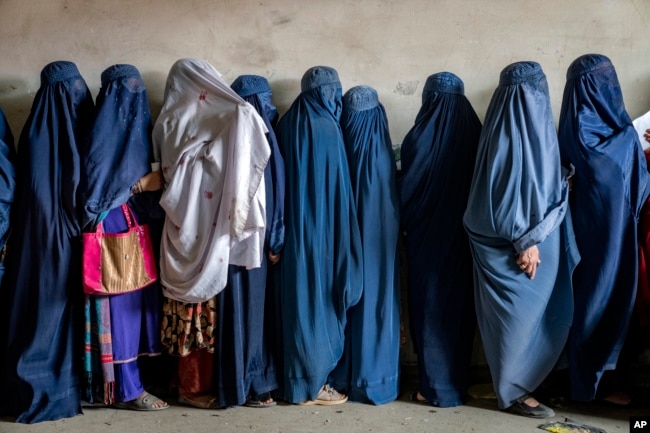 FILE - Afghan women wait to receive food rations distributed by a humanitarian aid group, in Kabul, Afghanistan, on May 23, 2023.