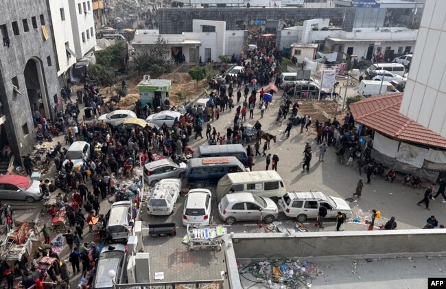 FILE - Displaced Palestinians gather in the yard of Gaza's Al-Shifa hospital, Dec. 10, 2023.