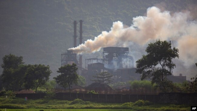 FILE - Smoke rises from a coal-powered steel plant at Hehal village near Ranchi, in eastern state of Jharkhand, Sept. 26, 2021. (AP Photo/Altaf Qadri, File)