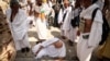 مردی بر اثر گرمای سوزان در میان نگاه دیگر زائران در محل مراسم نمادین «سنگسار شیطان» در مراسم حج روی زمین افتاده است - ژوئن ۲۰۲۴