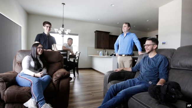 El doctor Kyle Varner, segundo desde la derecha y quien patrocina a venezolanos que llegan a Estados Unidos a través del parole humanitario, recibe en su casa a beneficiarios de este programa, el 6 de enero de 2023, en Spokane, en el estado de Washington, EEUU.