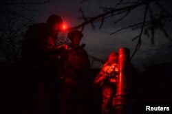 Ukrainian servicemen prepare to fire a mortar, as Russia's attack on Ukraine continues near the city of Bakhmut, Donetsk region, Ukraine, April 6, 2023.