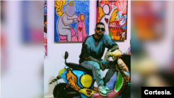 El venezolano Pedro Martín posa frente a sus obras de graffiti para exposición su obra en una galería de arte en Miami, Florida.