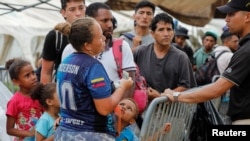 Migrantes que se dirigen a Estados Unidos esperan para abordar un autobús que los llevará a la frontera con Costa Rica en la Estación de Recepción de Migrantes en Lajas Blancas, provincia de Darién, Panamá, 23 de septiembre de 2023.